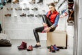 Woman trying shoes for hiking in the shop