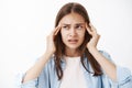 Woman trying think and act in tough situation holding fingers on temples frowning gazing aside having lack of