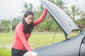 Woman trying to fix her broken car Royalty Free Stock Photo