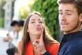Woman trying to kiss a man and he is rejecting her