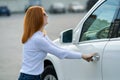 A woman trying to open closed car doors