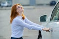 A woman trying to open closed car doors