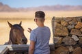 Woman trying to pet a wild horse in the Namib desert near Luderitz, Namibia Royalty Free Stock Photo