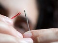 Woman trying to thread needle