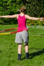 Woman turn spin hula hoop ring on waist in garden
