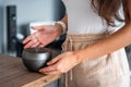 Woman turned on grey aroma oil diffuser on light table at home, air freshener Royalty Free Stock Photo