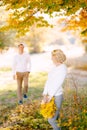 Woman turned to the approaching man. Woman holding a wreath of yellow leaves in her hands Royalty Free Stock Photo