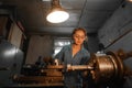 Woman turner in production near the lathe. Profession concept Turner, Metalworking, Turning, Industry, Metal.