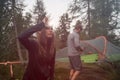 Woman turning on headlamp flashlight near hanging tent camping. Group of friends people summer adventure journey in Royalty Free Stock Photo