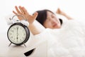 Woman turning off the alarm clock on the bed Royalty Free Stock Photo