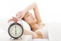 Woman turning off the alarm clock on the bed Royalty Free Stock Photo