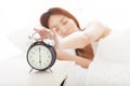 Woman turning off the alarm clock on the bed Royalty Free Stock Photo