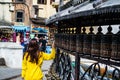 Woman Turning the Prayer Wheels at Monkey Temple Swayambhunath in Kathmandu, Nepal