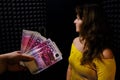 The woman turns away from the money on a black background. Payment for recording a song at the concert of the singer. Refusal to