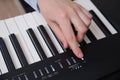 Woman turns on the electric piano, hand on the start button close-up