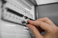 A woman turns off the light in the house in the electrical cabinet. Power, energy saving, energy saving