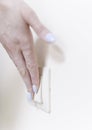 The woman turns off and turns on the light with a white switch on the wall, close-up. Control of utilities Royalty Free Stock Photo