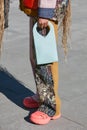 Woman with turquoise Marco Rambaldi leather bag and palstic clogs before Marco Rambaldi fashion