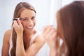 Woman, tweezers and eyebrow in bathroom portrait for skincare, beauty or self care for face in mirror. Girl, facial hair Royalty Free Stock Photo