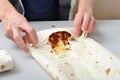 Woman twists ready-made shawarma into pita bread Royalty Free Stock Photo