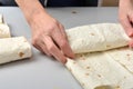 Woman twists ready-made shawarma into pita bread Royalty Free Stock Photo