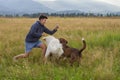 Woman with two dogs plays in a meadow Royalty Free Stock Photo