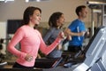 Woman and two young adults running on treadmills at a gym Royalty Free Stock Photo