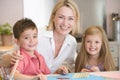 Woman and two young children in kitchen with art p Royalty Free Stock Photo