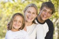 Woman with two young children outdoors smiling