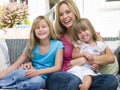 Woman and two young girls sitting on patio smiling Royalty Free Stock Photo