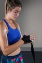 Woman tying hand wrap on hand in fitness studio