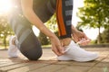 Woman tying laces of sneakers outdoors, closeup. Morning fitness Royalty Free Stock Photo