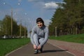 Woman tying shoe laces. Female sport fitness runner getting ready for jogging outdoors on forest path in spring or summer. Royalty Free Stock Photo