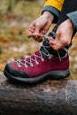 Woman tying shoelace on her hiking boot in autumn forest Royalty Free Stock Photo