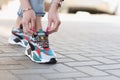 Woman tying shoelaces on sports sneakers closeup