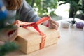 Woman tying xmas gift box with ribbon. Process of package xmas Royalty Free Stock Photo