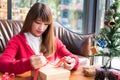 Woman tying xmas gift box with ribbon. Process of package xmas Royalty Free Stock Photo