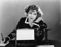 Woman at typewriter on telephone Royalty Free Stock Photo
