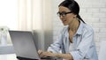 Woman typing on laptop chatting in social network, answering messages online Royalty Free Stock Photo