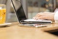 Woman typing on a laptop keyboard in a warm sunny day outdoors, sitting at the cafe table. Space for text Royalty Free Stock Photo