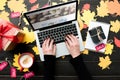 top view of woman typing on laptop with website on wooden tabletop with foliage Royalty Free Stock Photo