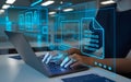 woman typing on a laptop in workspace. The laptop screen displays a holographic interface with blue glowing wireframe documents Royalty Free Stock Photo