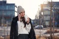 Smiling woman with smart phone and coffe to go standing outdoors and speaking. Modern lifestyle concept.