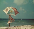 woman with umbrella on the beach, vintage color tone, retro style Royalty Free Stock Photo