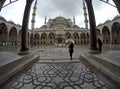 Woman with an umbrella at Blue Mosque courtyard Royalty Free Stock Photo