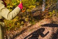 A woman with an umbrella casts a harsh shadow in an autumn park