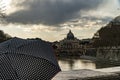 Woman with umbrella in front of the Papal Basilica of St. Peter, west of River Tiber in Rome, Italy