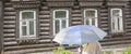 Woman with an umbrella. An old house from the times of the Russian Empire in the center of the city of Penza.