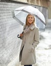 Woman, umbrella and portrait with rain in street, pride and smile with cover, weather and splash in city. Person