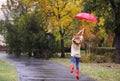 Woman with umbrella taking walk in autumn park